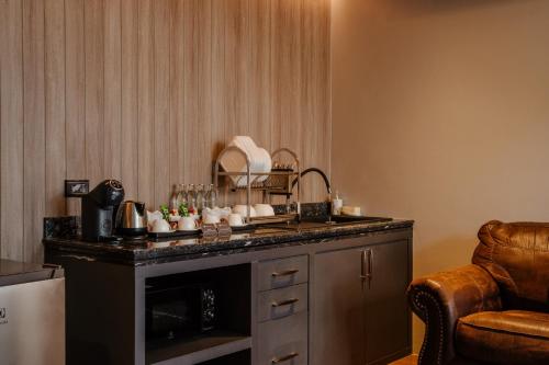 a kitchen with a counter with dishes on it at Richmann Resort Hotel Hatyai in Hat Yai