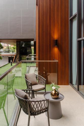 a patio with two chairs and a table on a balcony at Richmann Resort Hotel Hatyai in Hat Yai