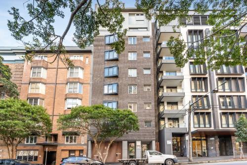 an apartment building with cars parked in front of it at Pyrmont Apartments by Urban Rest in Sydney