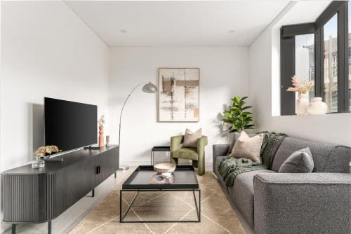 a living room with a couch and a tv at Pyrmont Apartments by Urban Rest in Sydney