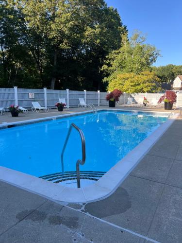 a swimming pool with a diving board in the middle at Newly Renovated Loft Villa at Norwich Spa with amenities, 3 minutes to Mohegan in Norwich