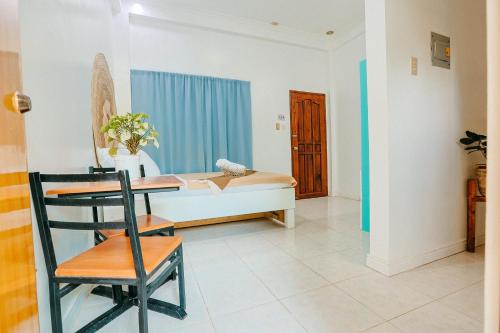 a room with a bed and a table and a chair at Tahan Hostel in Puerto Princesa City