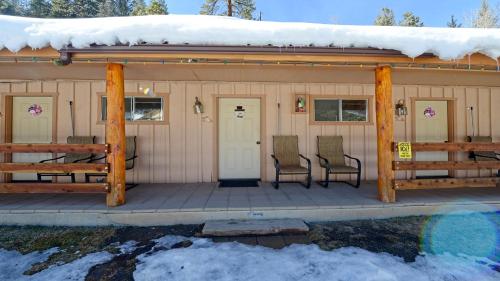 una baita con sedie e un portico nella neve di Arrowhead 15 a Red River