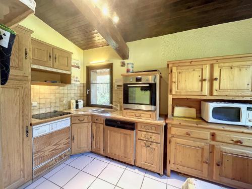 une grande cuisine avec des armoires et des appareils en bois dans l'établissement 2 Pièces + Mezzanine au pied des pistes avec Parking - Combloux - FR-1-560-64, à Combloux