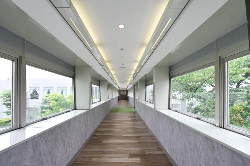 a corridor of windows in a building with wooden floors at Tokushima Grandvrio Hotel in Tokushima