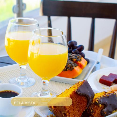 a table with two glasses of wine and a plate of food at Bela Vista Hotel in Arujá
