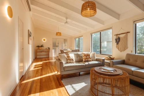 a living room with a couch and a table at Roderick Beach House Pet Friendly in Caloundra