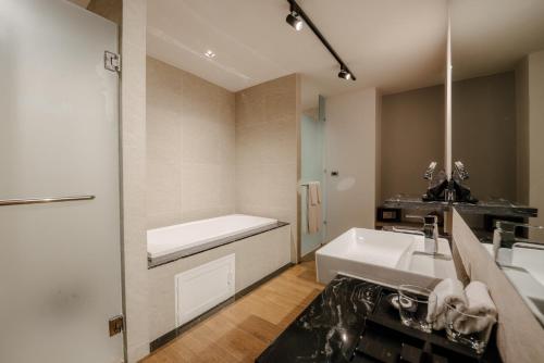a bathroom with a sink and a bath tub at Richmann Resort Hotel Hatyai in Hat Yai