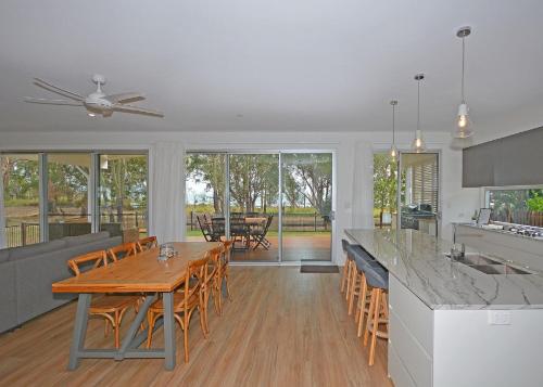 a kitchen and dining room with a wooden table and chairs at Beachside - Burrum Heads- Beachfront - 3BR- Wifi in Burrum Heads