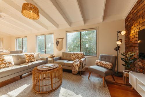 a living room with a couch and a table at Roderick Beach House Pet Friendly in Caloundra