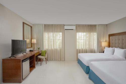 a hotel room with two beds and a television at Holiday Inn & Suites Batangas LimaPark by IHG in Batangas City