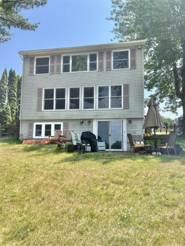 a large house with a table and chairs in the yard at SEBAGO ESCAPE LIMIT 12 home in Raymond