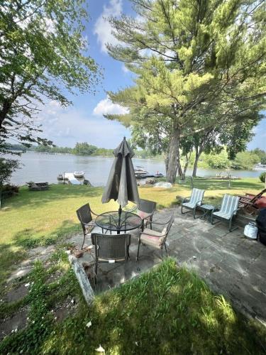 a patio with chairs and a table and an umbrella at SEBAGO ESCAPE LIMIT 12 home in Raymond