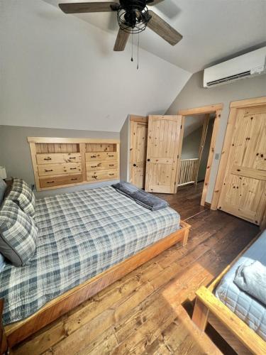 a bedroom with a bed and wooden floors and a ceiling at EVA'S PLACE LIMIT 7 home in North Sebago