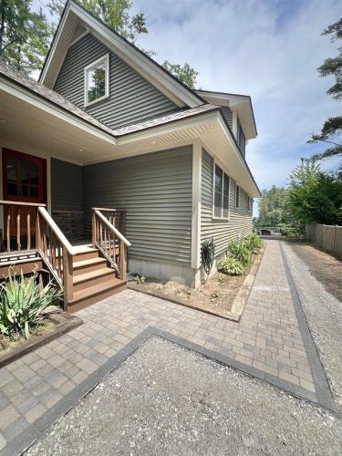 a house with a porch and a driveway at EVA'S PLACE LIMIT 7 home in North Sebago