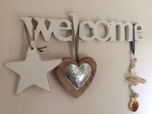 a wooden heart and a star and the word welcome at Sunnychalet in Beekbergen