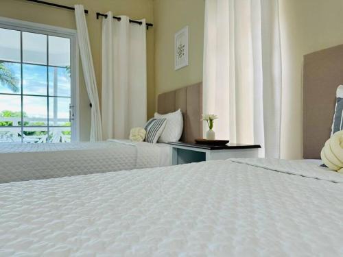 a hotel room with two beds and a window at Falcon Sunset 2br- Airport Transport Available -Security-Gated in Montego Bay