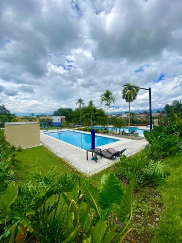 a pool with a blue bench in the grass at Apartasol Reserva de la Colina Lindo y Cómodo Apartamento in La Tebaida