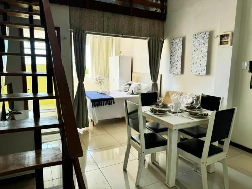 a dining room with a table and chairs and a bedroom at Boutique FLAT 1 min da Praia in Luis Correia