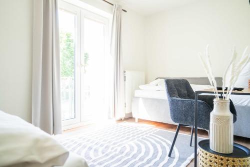 a bedroom with a bed and a vase on a table at Johouse Zingst Johouse Zimmer 10 in Zingst