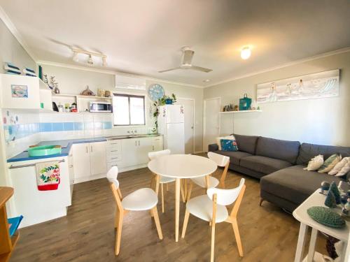 a kitchen and living room with a table and a couch at The Batch in Toogoom