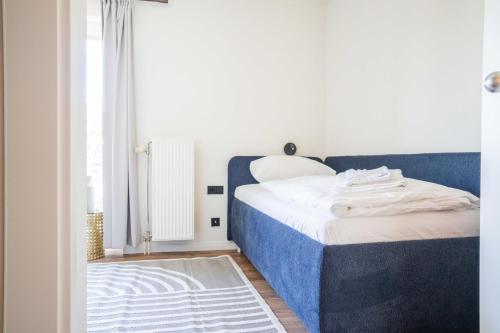 a bedroom with a blue and white bed and a window at Johouse Zingst Johouse Zimmer 13 in Zingst