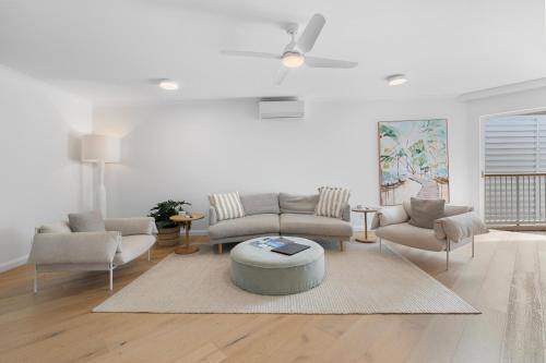 a living room with a couch and chairs and a table at Serenity Apartments Noosa in Noosa Heads