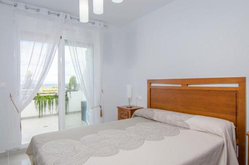 a bedroom with a bed and a large window at Novabeach by Mar Holidays in Puerto Marino