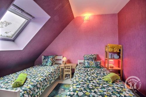 a attic bedroom with two beds and a table at Les 2 pointes in Plouézec