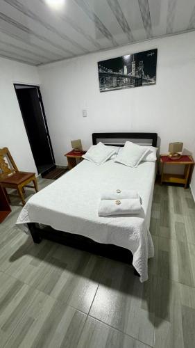 a bedroom with a bed with two towels on it at Hermosa casa de campo en Barbosa in Barbosa