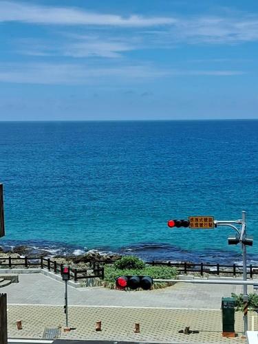 a traffic light with the ocean in the background at 看海民宿 in Eluan