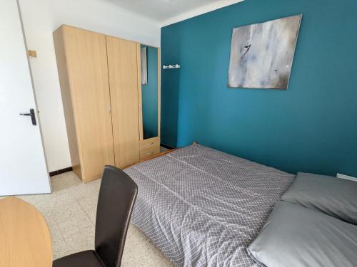une chambre avec un lit et un mur bleu dans l'établissement T2 face mer, climatisé, parking privé, 4 pers - FR-1-797-11, à Port-la-Nouvelle