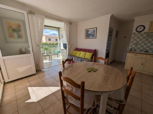 - une cuisine et une salle à manger avec une table et un canapé dans l'établissement Appartement T2 lumineux 40m2, 4 personnes, 150m de la plage, bien équipé et proche loisirs - FR-1-797-18, à Port-la-Nouvelle