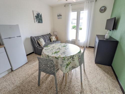 un salon avec une table, des chaises et un canapé dans l'établissement Confortable T2 rénové, plain-pied, cour privative + balcon, parking, proche mer - FR-1-797-20, à Port-la-Nouvelle