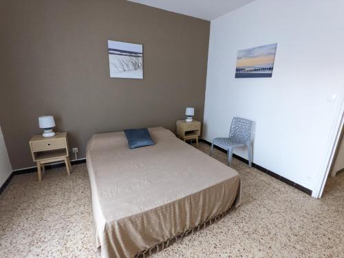 - une chambre avec un lit, deux tables et une chaise dans l'établissement Confortable T2 rénové, plain-pied, cour privative + balcon, parking, proche mer - FR-1-797-20, à Port-la-Nouvelle