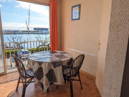 une salle à manger avec une table et des chaises et un balcon dans l'établissement Appartement T4 proche plage et commerces, 80m2, 6 pers, lave-linge, TV - FR-1-797-23, à Port-la-Nouvelle