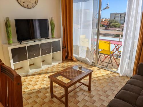 un salon avec une télévision et une table basse dans l'établissement Beau T3 Meublé 1* - Clim, Parking, Près Plage - FR-1-797-4, à Port-la-Nouvelle