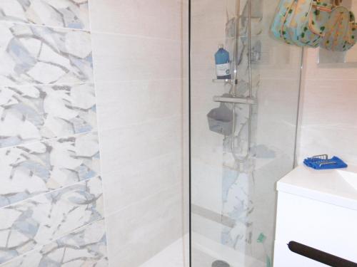 une douche avec une porte vitrée à côté d'un lavabo dans l'établissement T3 Climatisé RDC avec Terrasse, Parking, Proche Activités - Port-la-Nouvelle - FR-1-797-30, à Port-la-Nouvelle