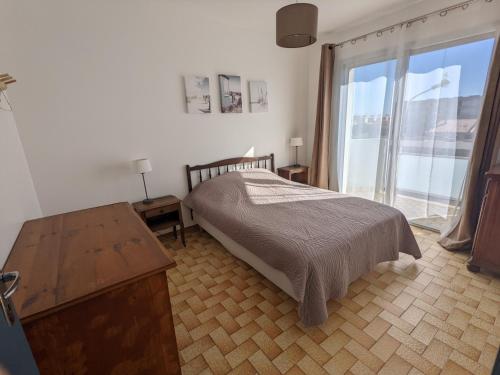 une chambre avec un lit et une grande fenêtre dans l'établissement Beau T3 Meublé 1* - Clim, Parking, Près Plage - FR-1-797-4, à Port-la-Nouvelle