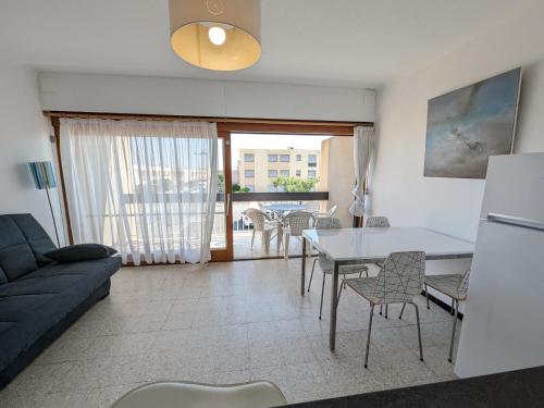 un salon avec un canapé, une table et des chaises dans l'établissement Agréable T2 pour 5 pers, 1er étage, climatisé, parking sécurisé - FR-1-797-6, à Port-la-Nouvelle