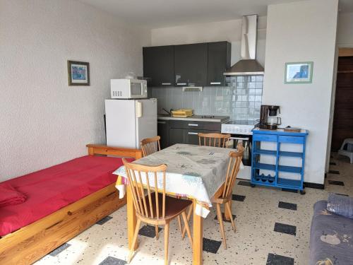 une cuisine avec une table, des chaises et un réfrigérateur dans l'établissement Port-la-Nouvelle : Studio front de mer, 4 pers, parking inclus - FR-1-797-32, à Port-la-Nouvelle