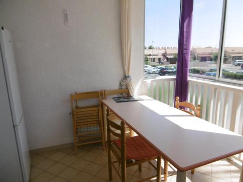 une pièce avec une table, des chaises et une fenêtre dans l'établissement Charmant T2 rénové climatisé avec parking privé à 450m de la plage, idéal pour 4 pers. - FR-1-797-8, à Port-la-Nouvelle