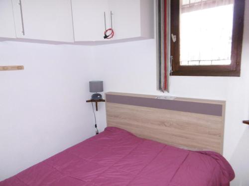 - une chambre avec un lit et une couverture violette dans l'établissement Charmant T2 rénové climatisé avec parking privé à 450m de la plage, idéal pour 4 pers. - FR-1-797-8, à Port-la-Nouvelle