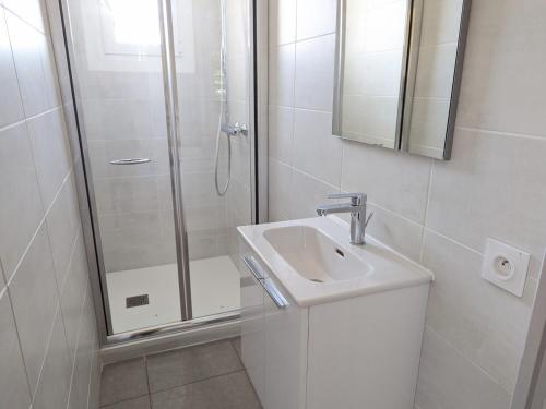une salle de bain blanche avec une douche et un lavabo dans l'établissement Port-la-Nouvelle : T2 proche plage, terrasse, parking, clim, BBQ, lave-linge, 4 pers, classé 2* - FR-1-797-17, à Port-la-Nouvelle