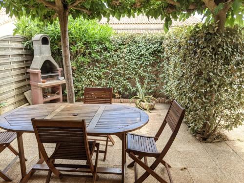 une table en bois avec des chaises et une cuisinière dans l'établissement Belle villa climatisée T3 avec mezzanine, jardin arboré, garage et à 900m de la plage, 6/7 personnes - FR-1-797-36, à Port-la-Nouvelle