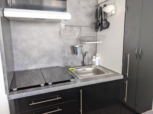 une petite cuisine avec un évier et un micro-ondes dans l'établissement T2 Front de Mer Vu latérale, 4 pers, Parking, Proche plage et animations - FR-1-797-16, à Port-la-Nouvelle