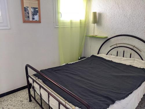 - un lit dans une chambre dotée d'un rideau vert dans l'établissement T2 Front de Mer Vu latérale, 4 pers, Parking, Proche plage et animations - FR-1-797-16, à Port-la-Nouvelle