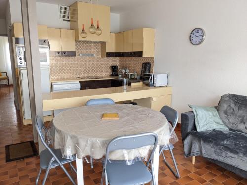 une cuisine avec une table et des chaises dans une pièce dans l'établissement T3 spacieux climatisé - 5 pers - près plage, centre & animations - Parking privé - FR-1-797-22, à Port-la-Nouvelle