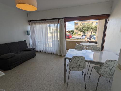 un salon avec un canapé, une table et des chaises dans l'établissement T2 Climatisé, 5 pers, Parking Protégé, Front de mer - FR-1-797-38, à Port-la-Nouvelle