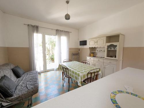 une cuisine et une salle à manger avec une table et des chaises dans l'établissement Agréable T2, 4 pers, plain-pied ouvert sur terrasse, jardin clos, parking privé, proche plage et commerces - FR-1-797-24, à Port-la-Nouvelle